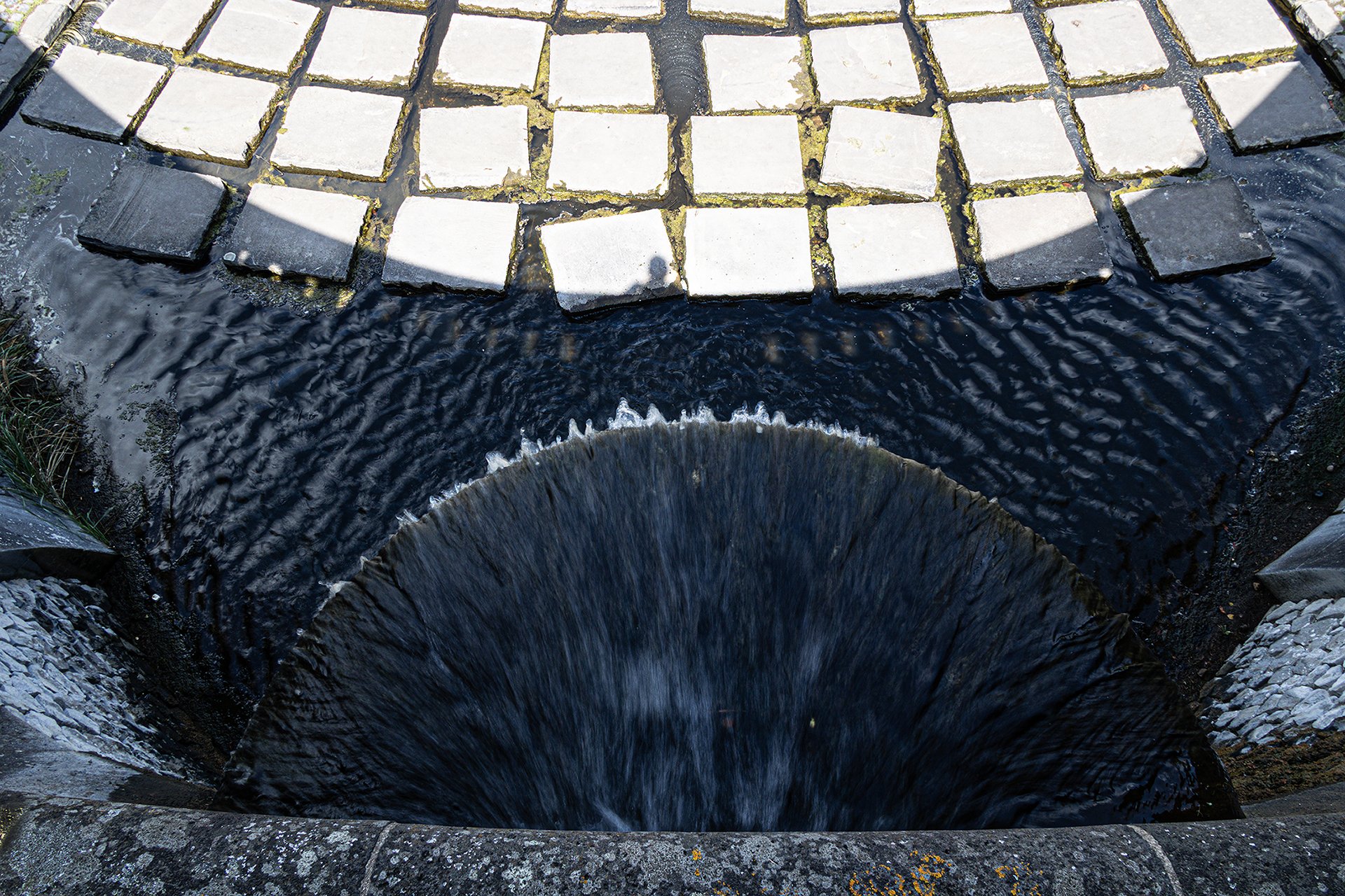 Schattenknipser über dem Brunnen
